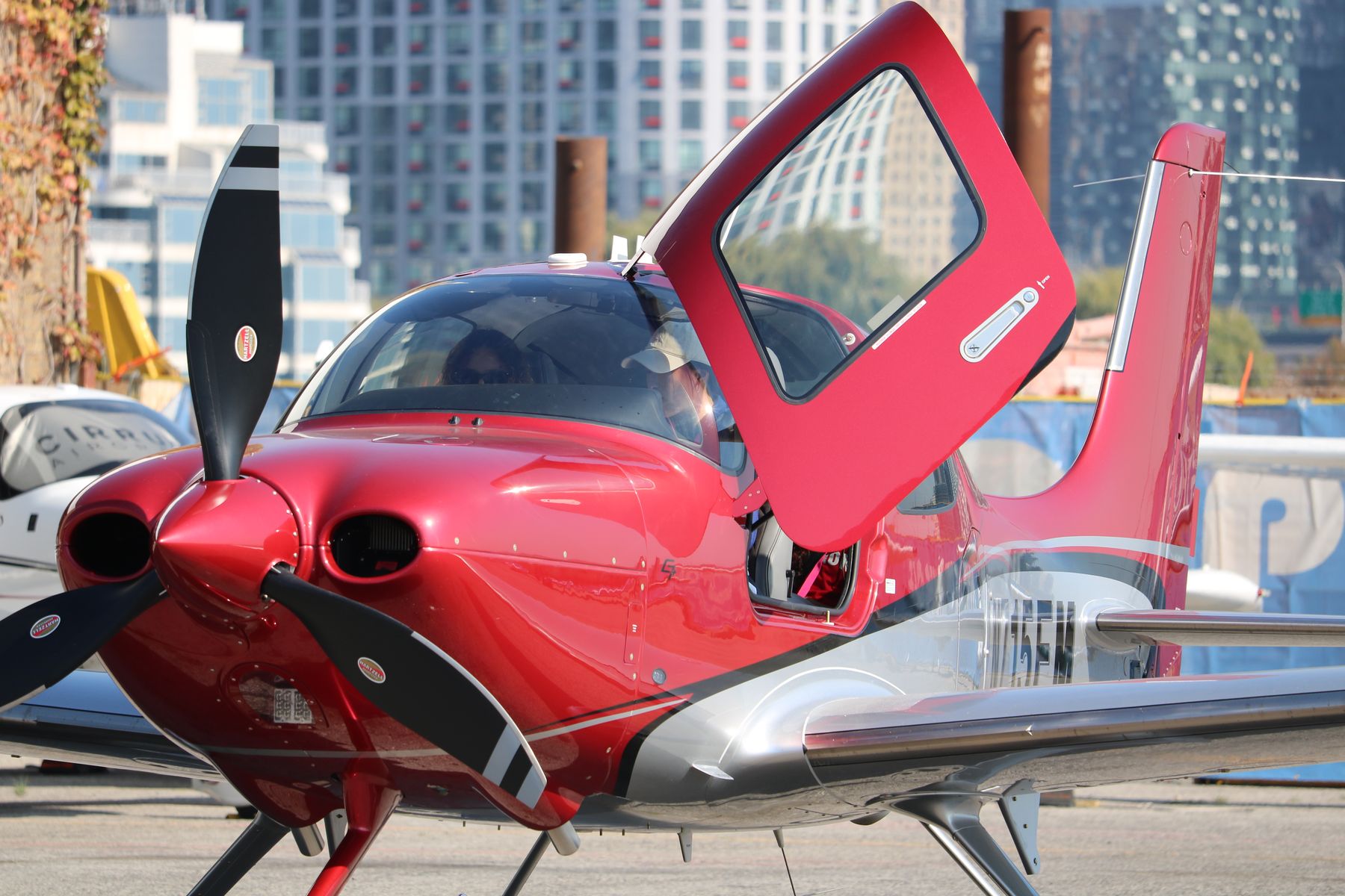 A Cirrus SR22 parked on the apron with the Toronto skyline behind